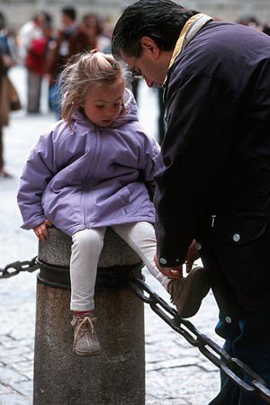 Father tying girl's shoelace