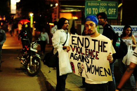 Young guy holding banner End the violence against women